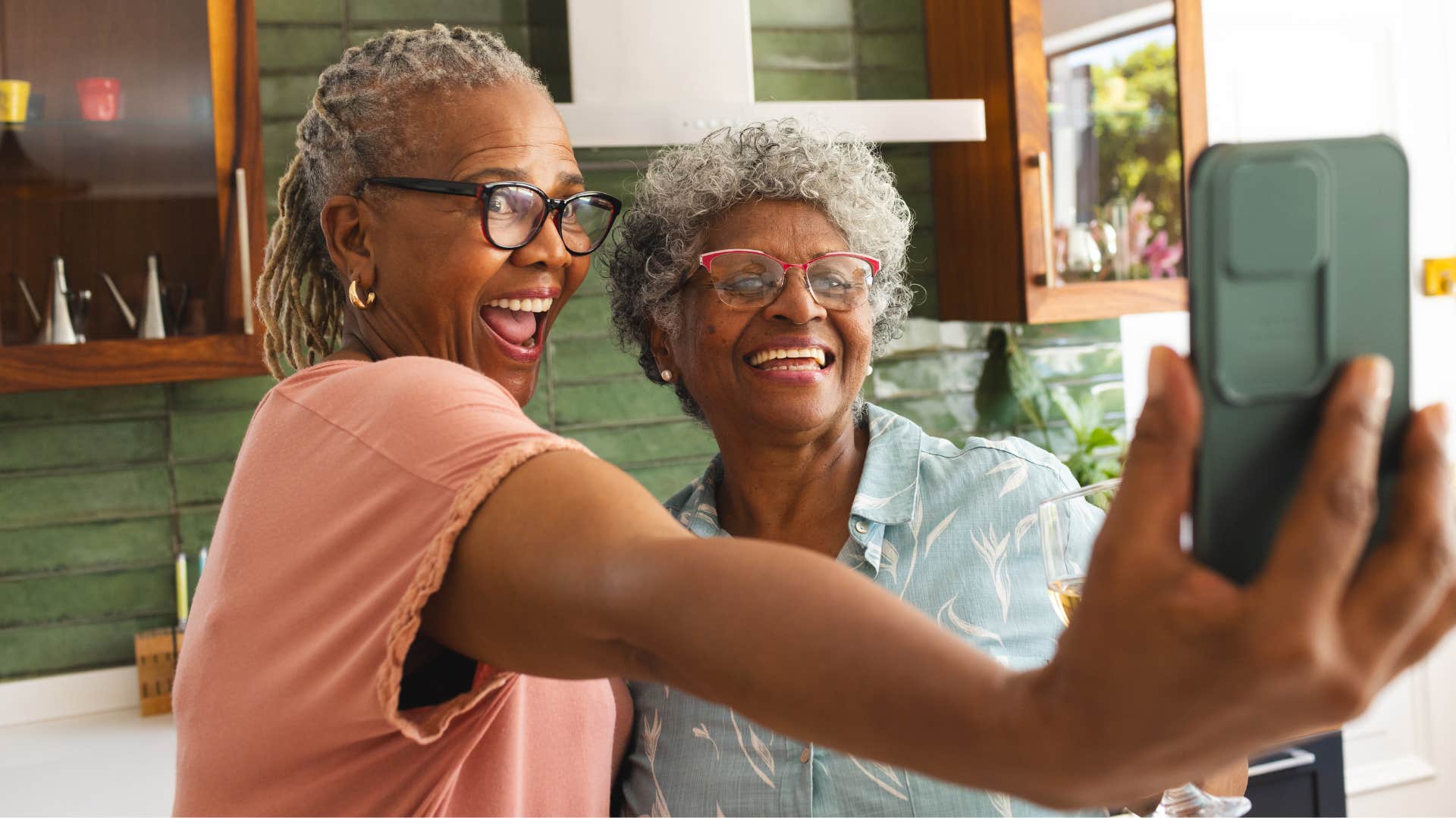 Two older women who are internally confident smiling for a picture.