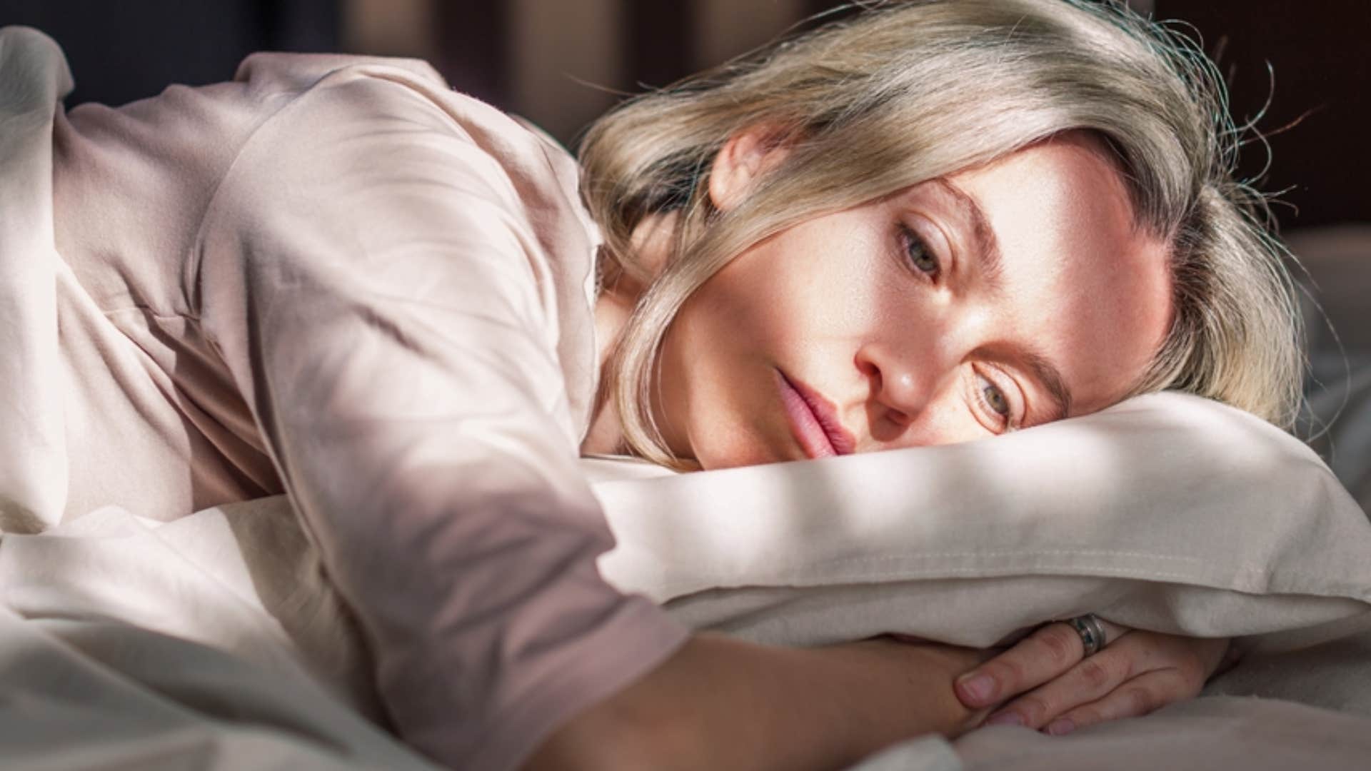 heartbroken woman lying in bed 