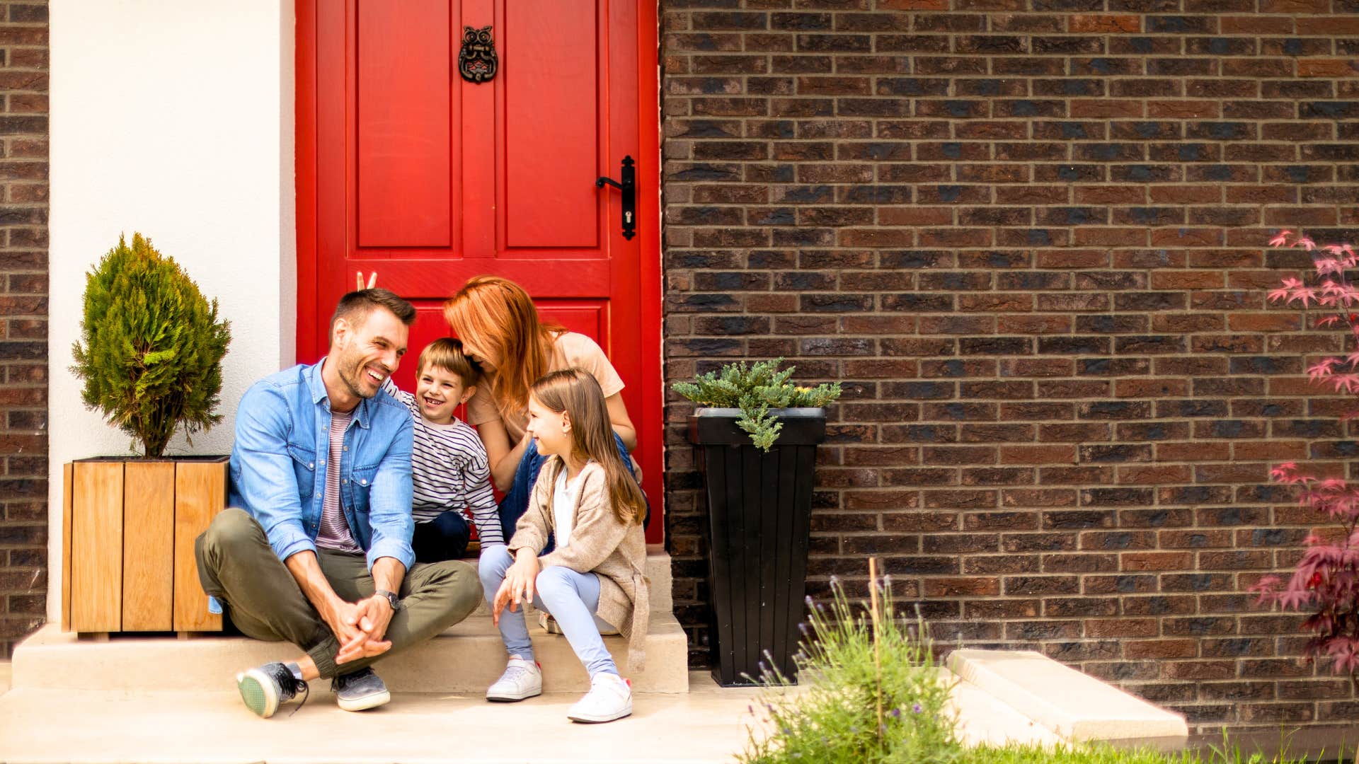 family sits together by their welcoming front door
