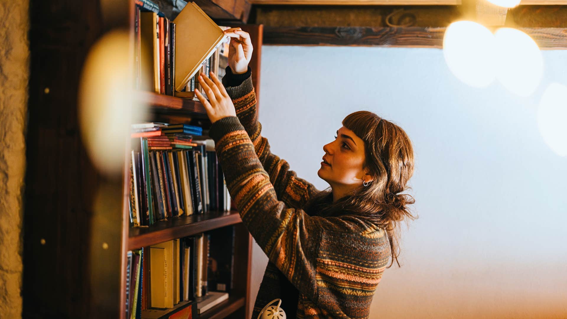 woman organizes a bookshelf in a space she made just for herself