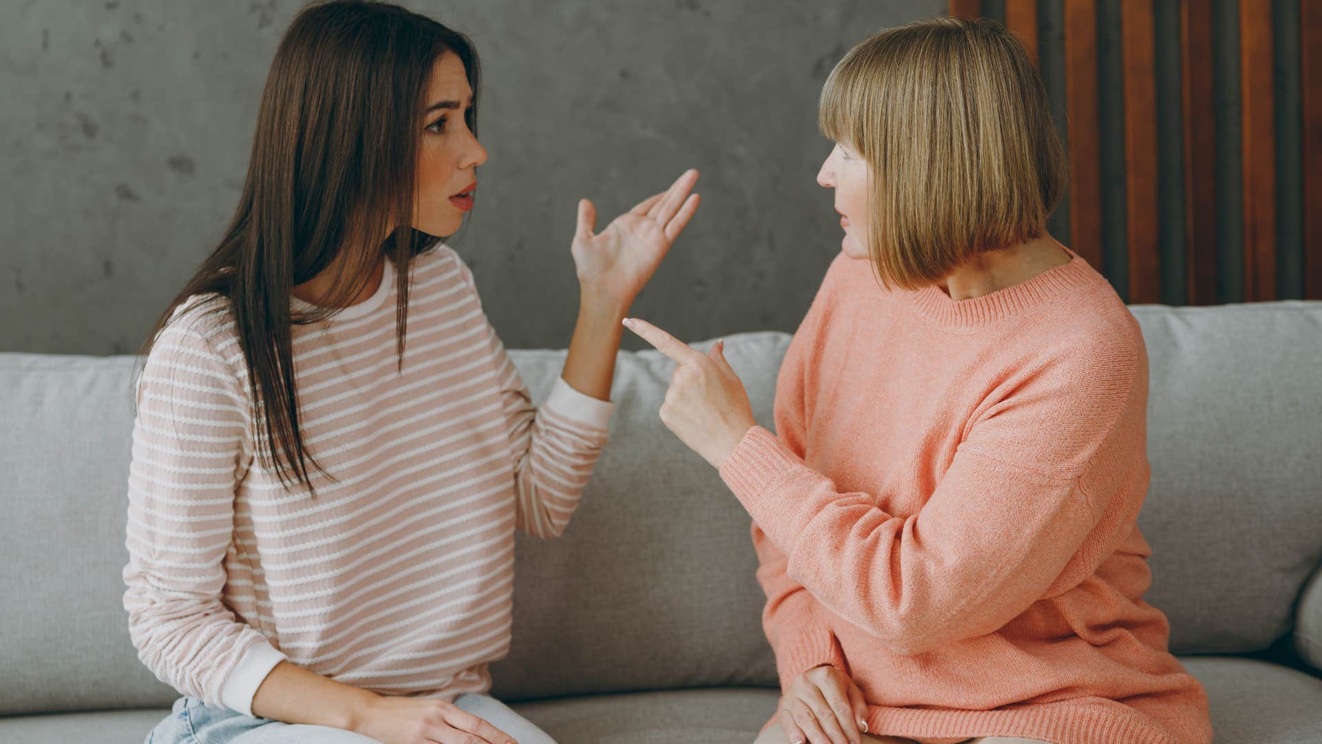 Woman saying "that's not a real job" to her upset adult daughter.