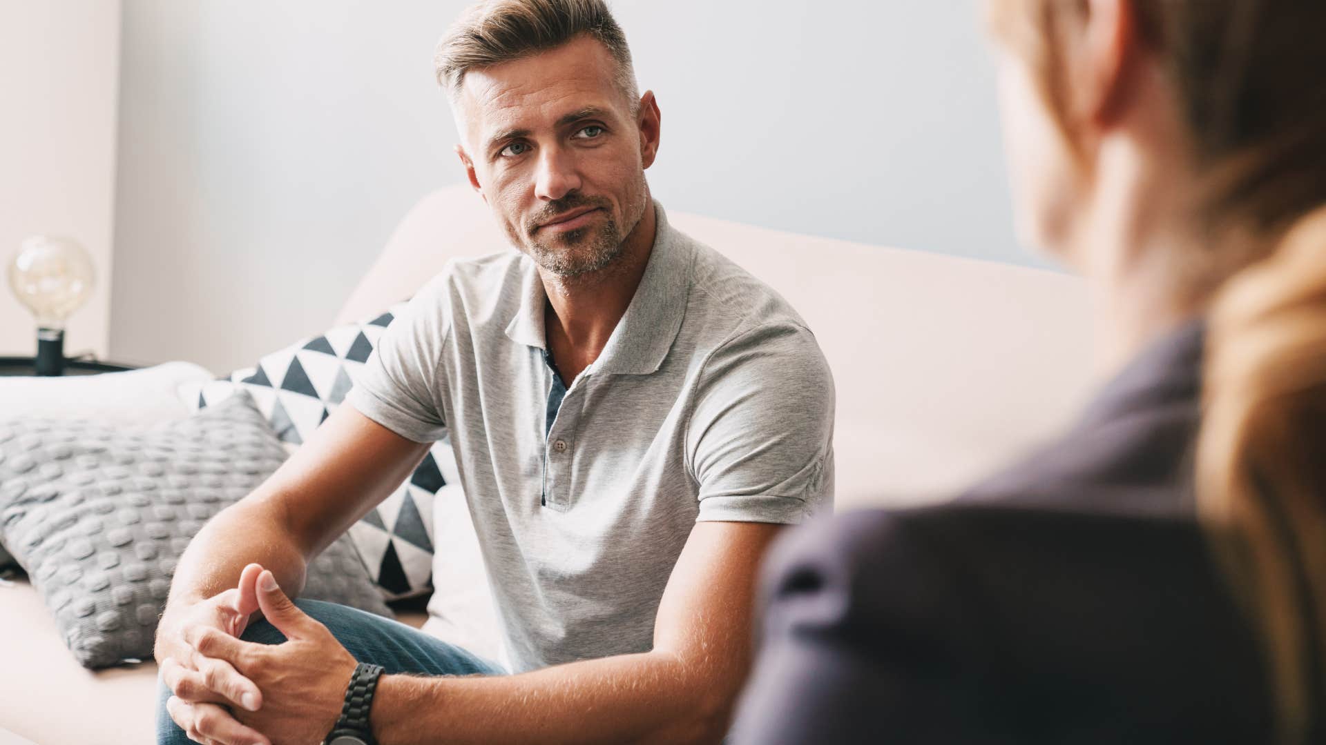 man asking woman what she heard and saw while sitting on couch