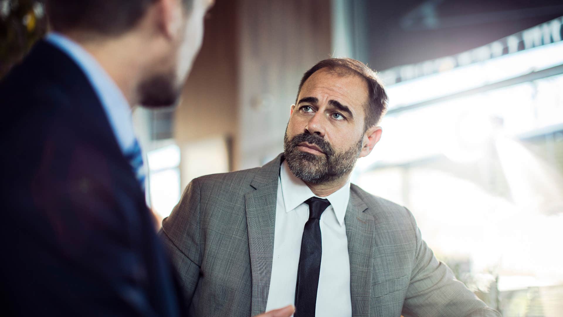 businessman having serious conversation with co-worker