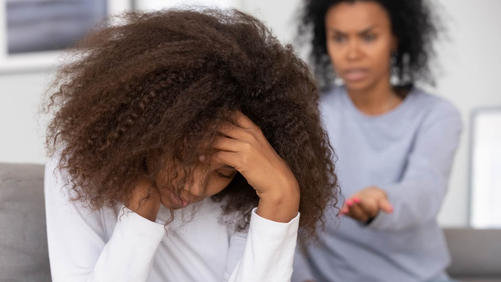 mom in gray shirt shouting stop crying or i'll give you something to cry about while daughter in white sweater looks distraught