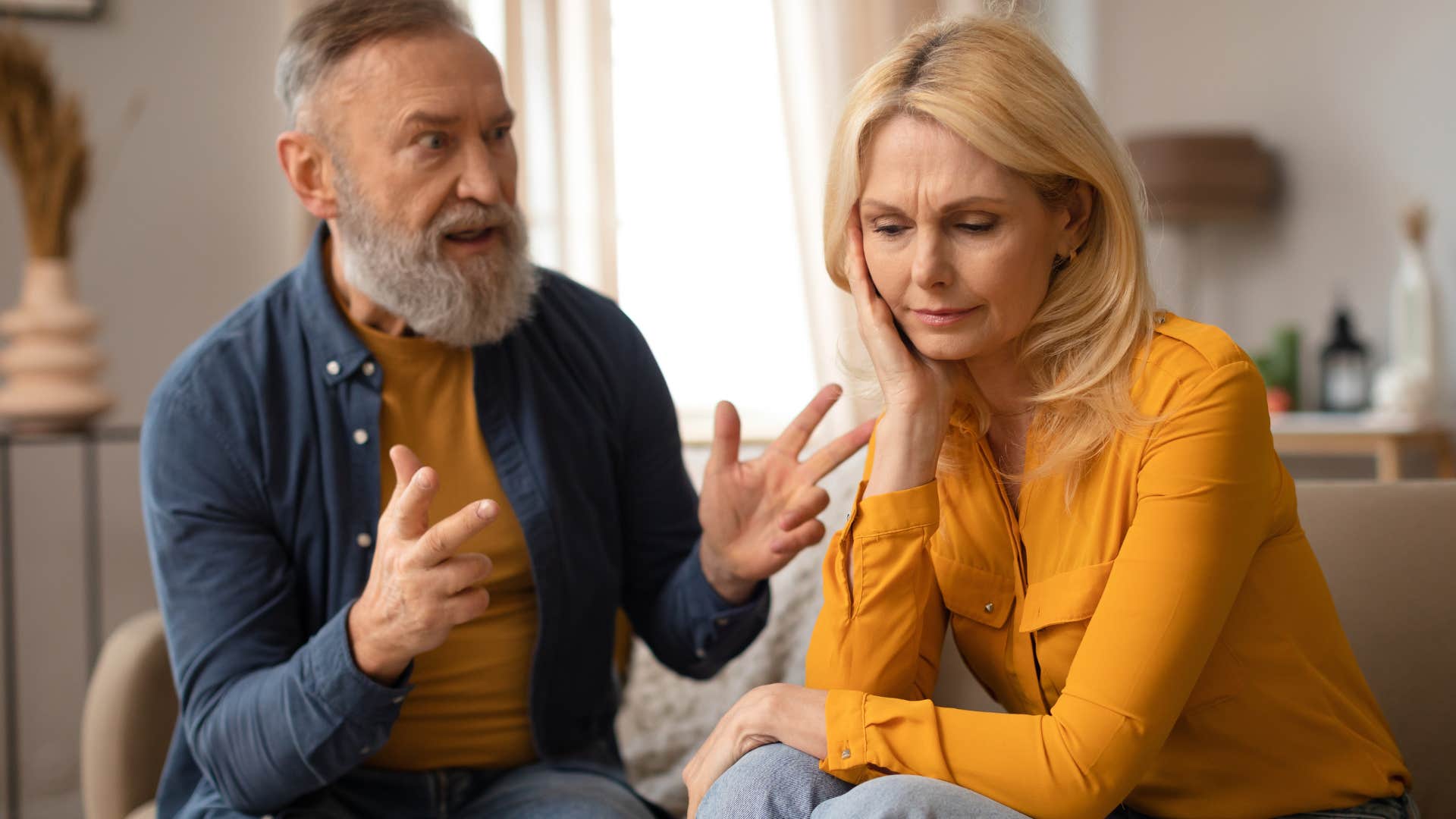 sad wife turned away from angry husband scolding her