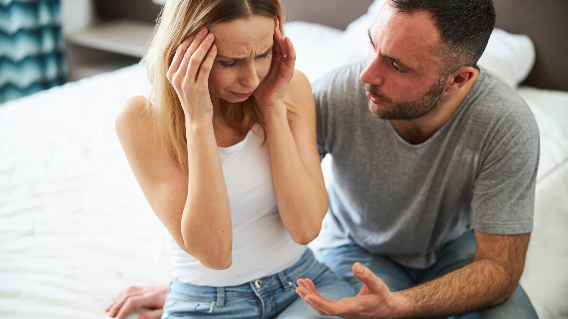 sad woman crying thinking it's her fault being consoled by man
