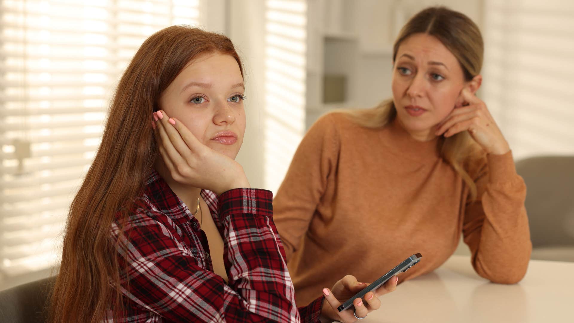 mother thinking them kids are raising cain to herself as daughter looks annoyed