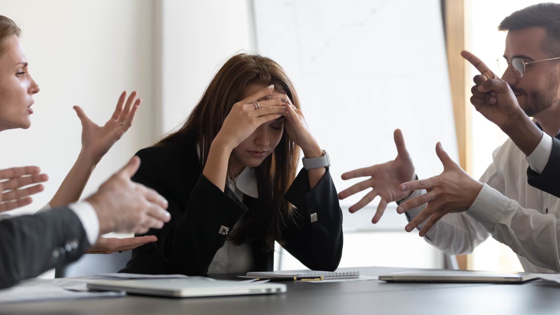 frustrated woman listening to colleagues argue