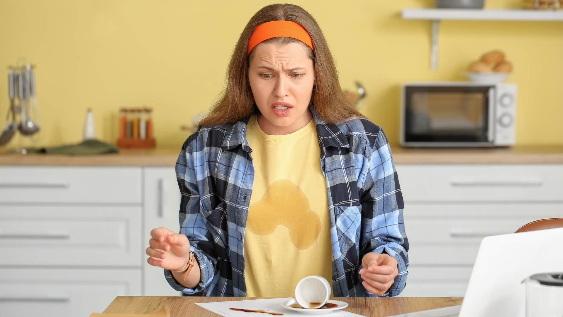 shocked woman who tumped over coffee over on table