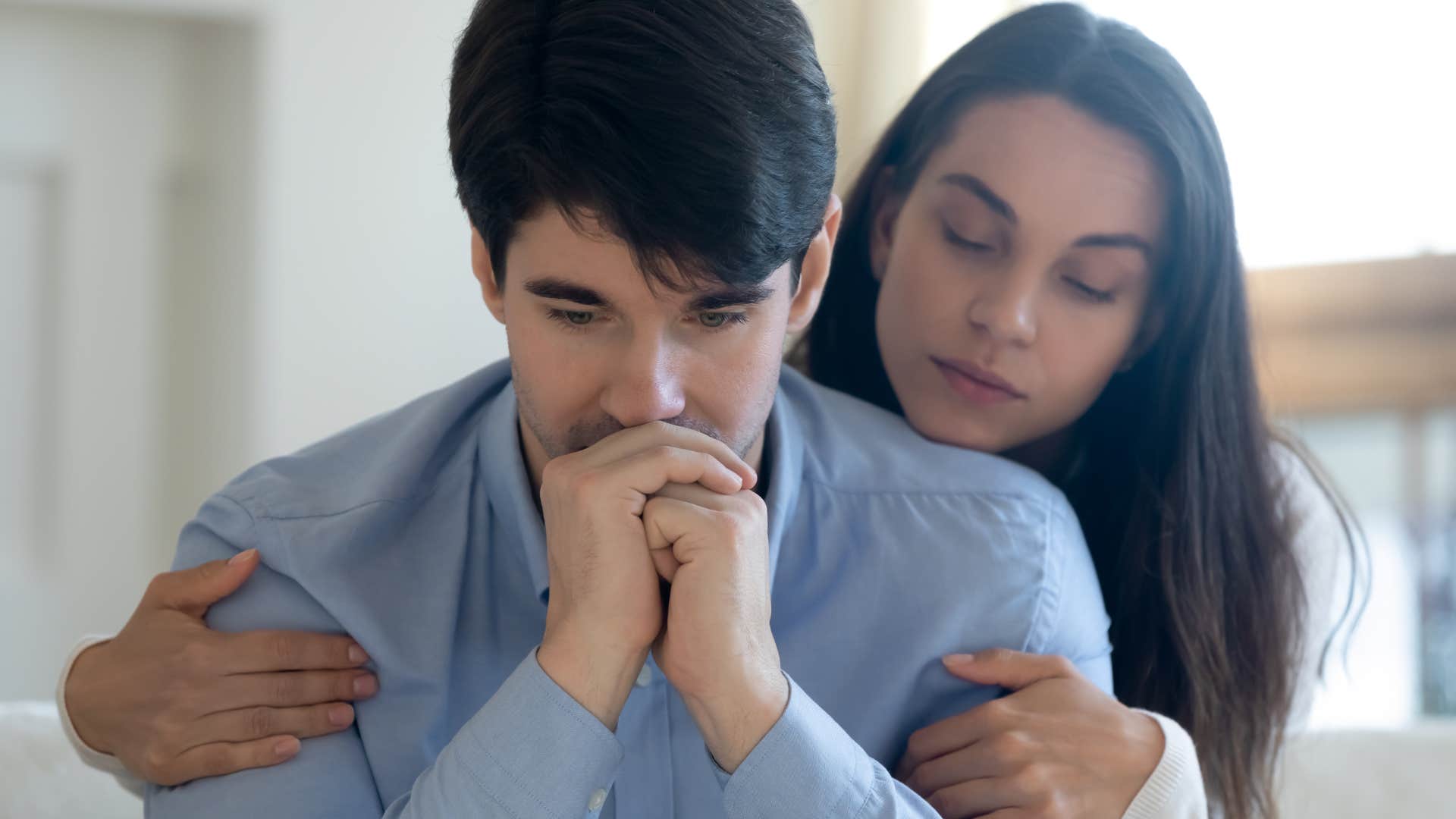 woman hugging man from behind thinking he still loves her