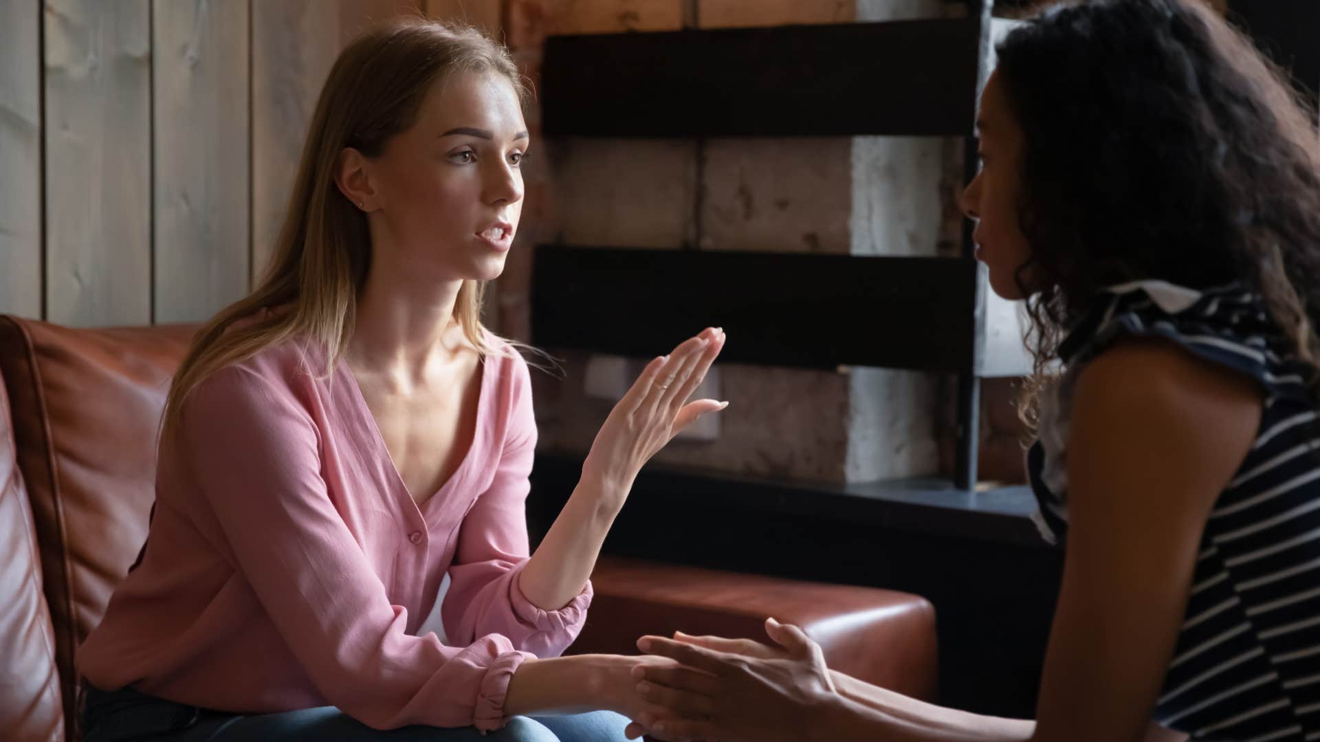 woman talking to friend apologizing for partner's behavior