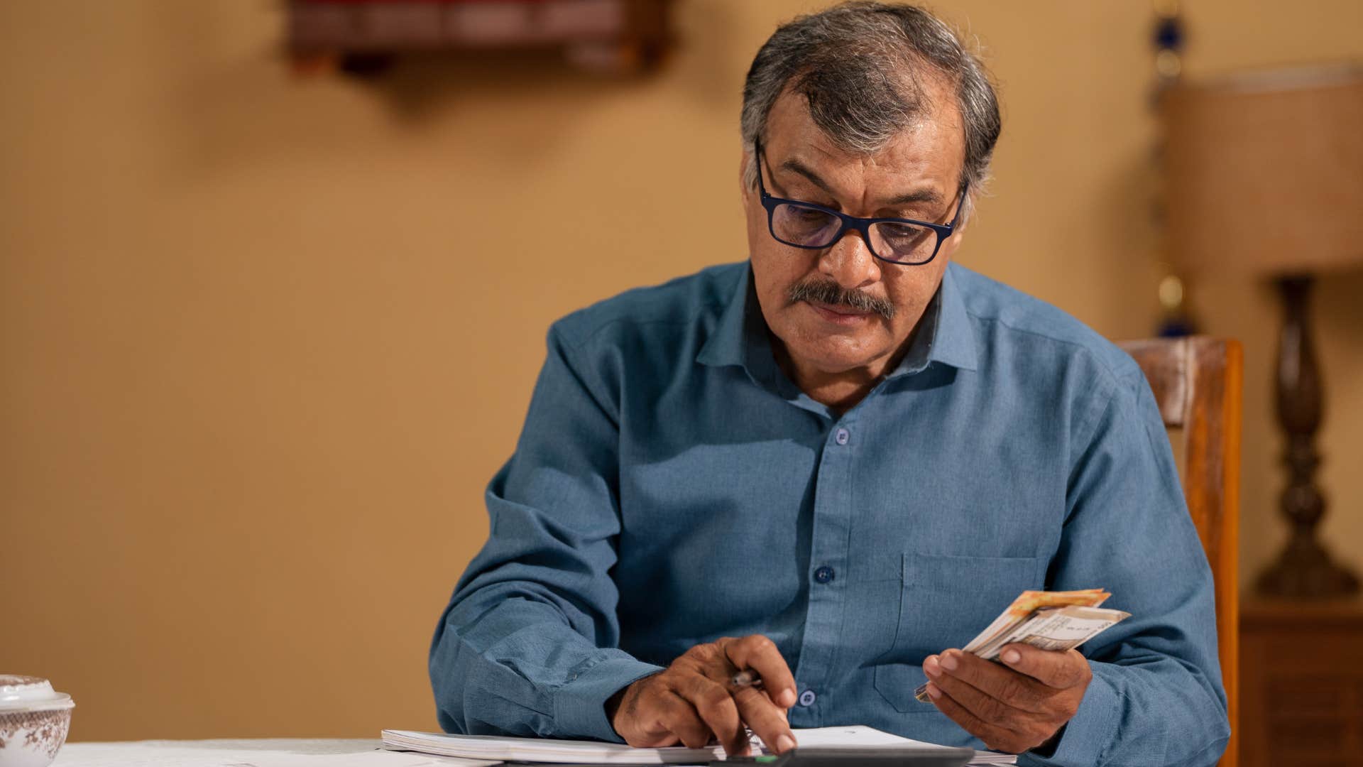 man who prefers cash over credit cards doing his bills