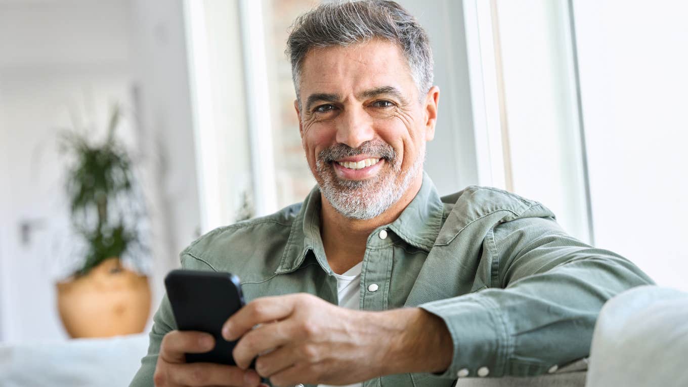 Quiet Superpowers People Who Grew Up Before Smartphones Usually Have middle aged man smiling holding his phone