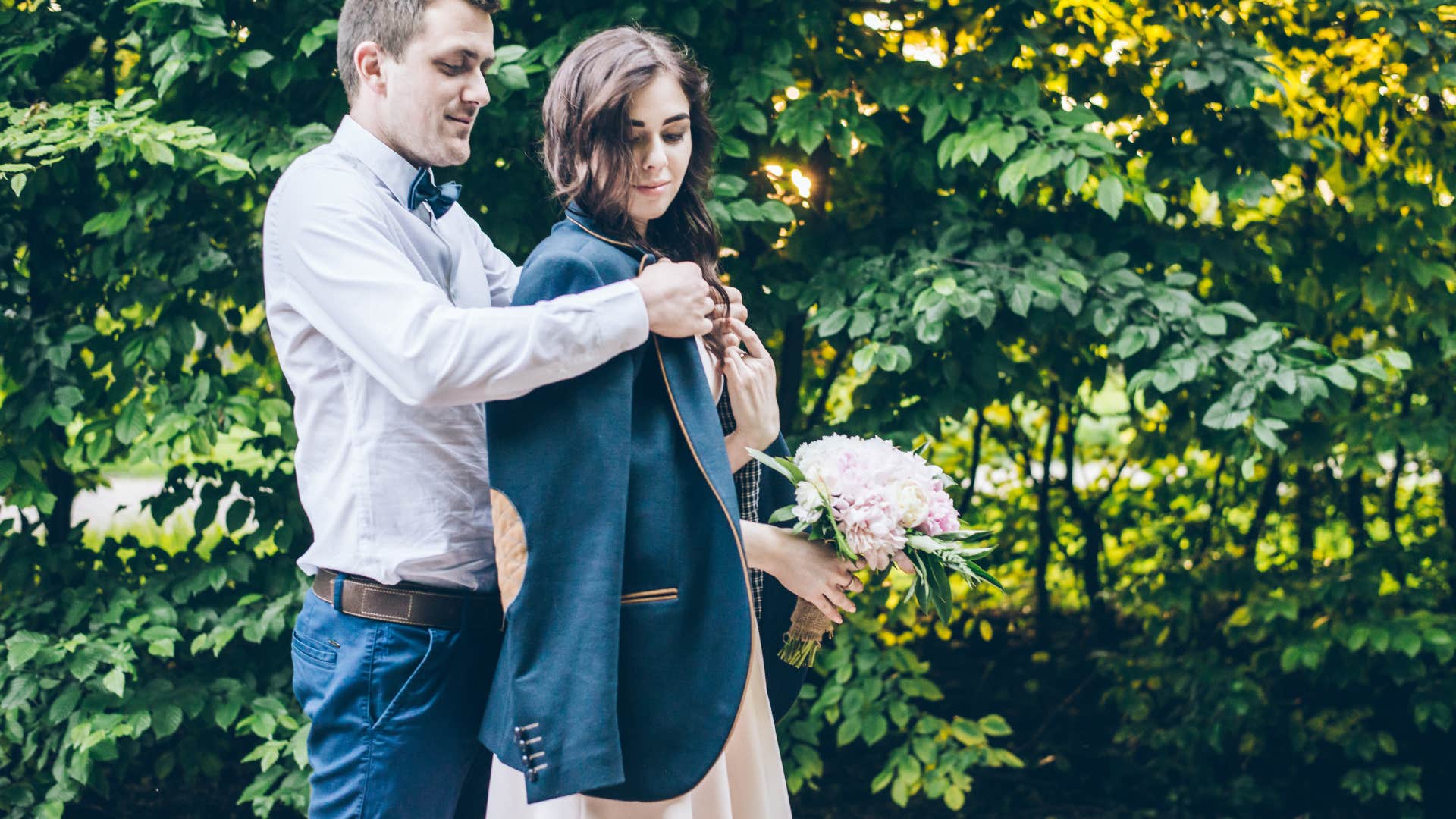man giving wife his jacket because shes cold