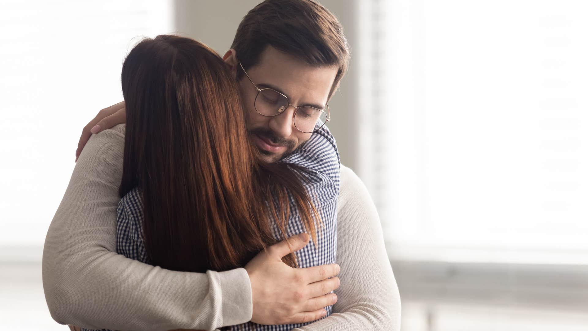 Man who doesn't raise his voice hugging his wife.