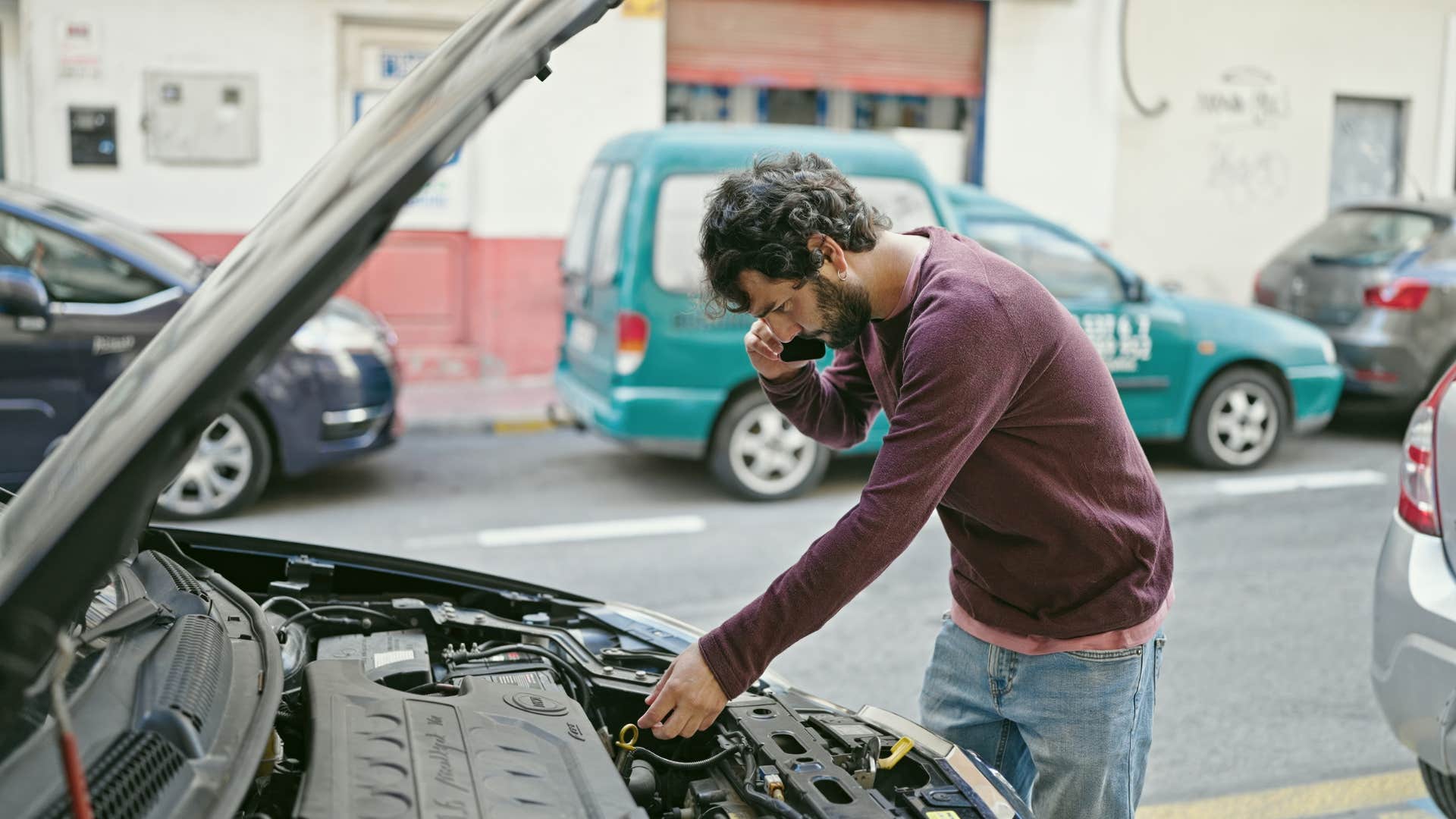 a boomer dad checks his daughters oil in her car