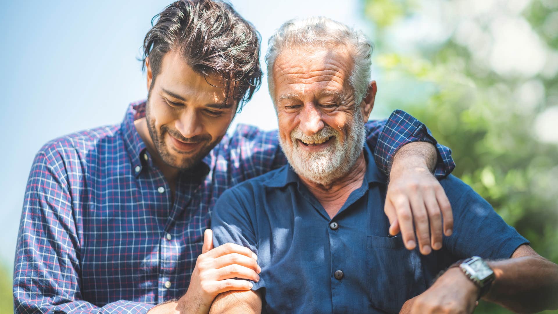 older man asking son for help smiling