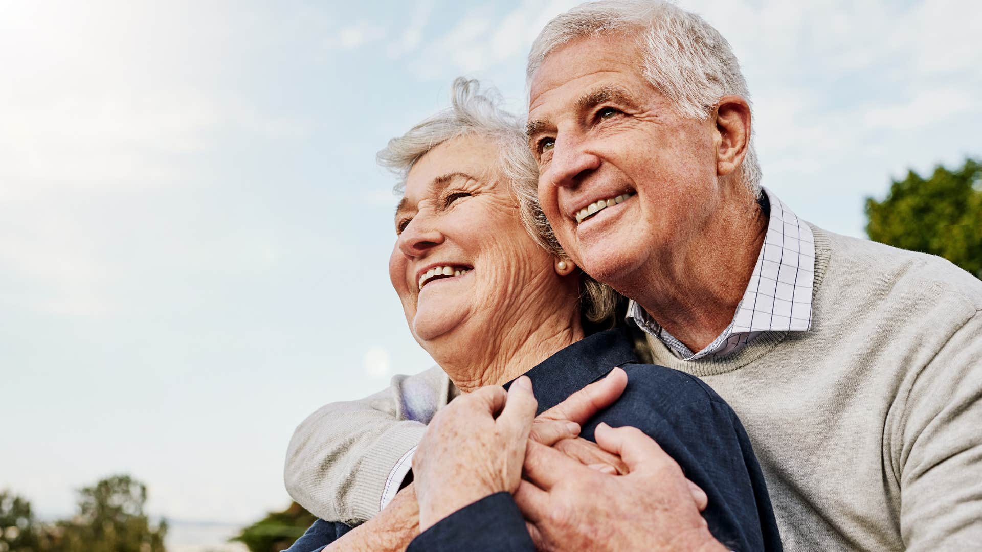 older man hugging his wife from behind