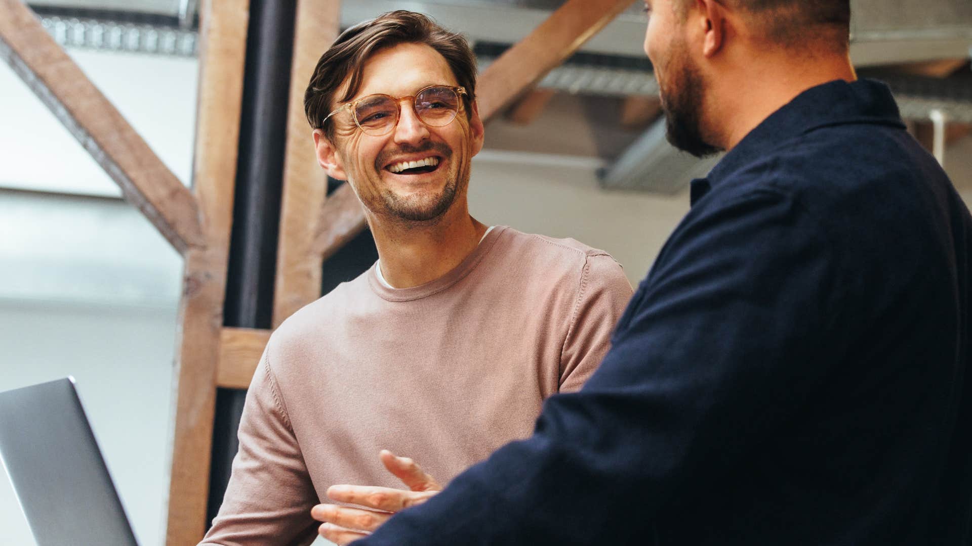 man being honest with co-worker smiling