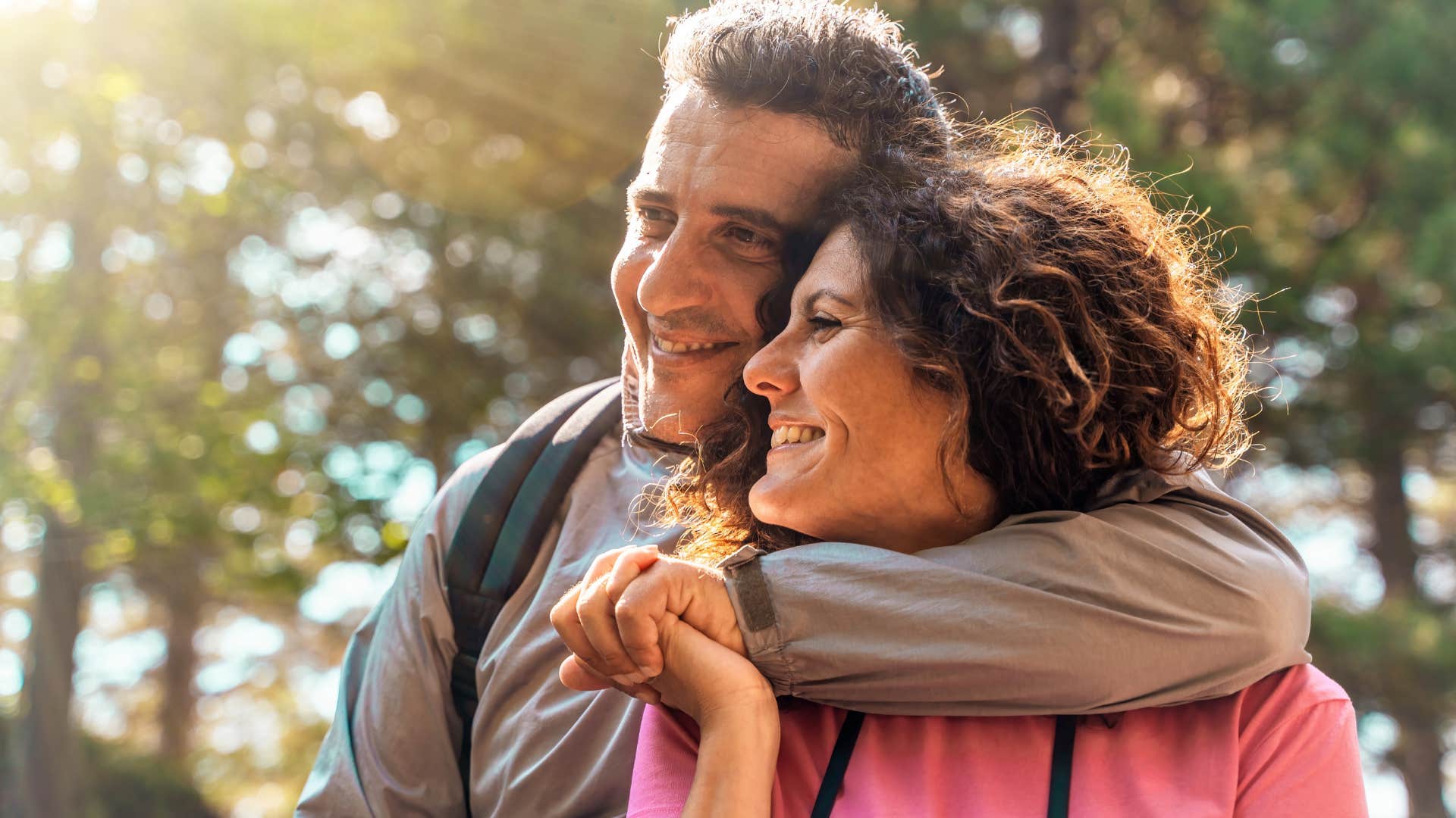 Man who shares burdens and success hugging his wife.
