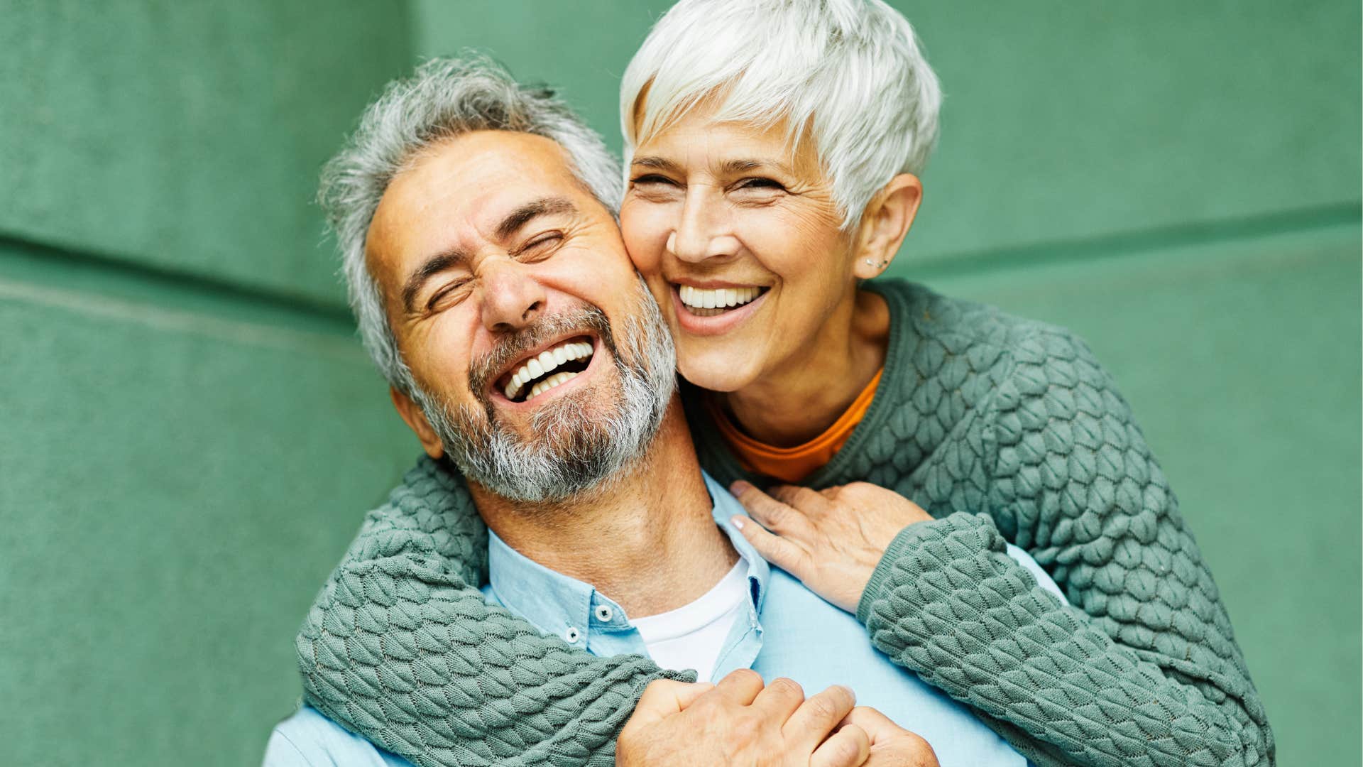 Man who grows with you smiling and hugging his wife.