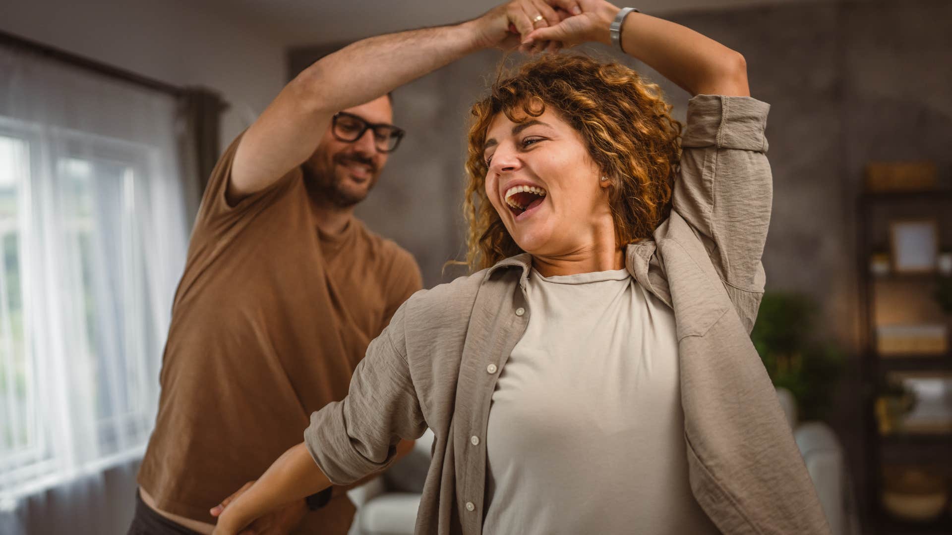 Man who makes quiet sacrifices dancing with his wife at home.