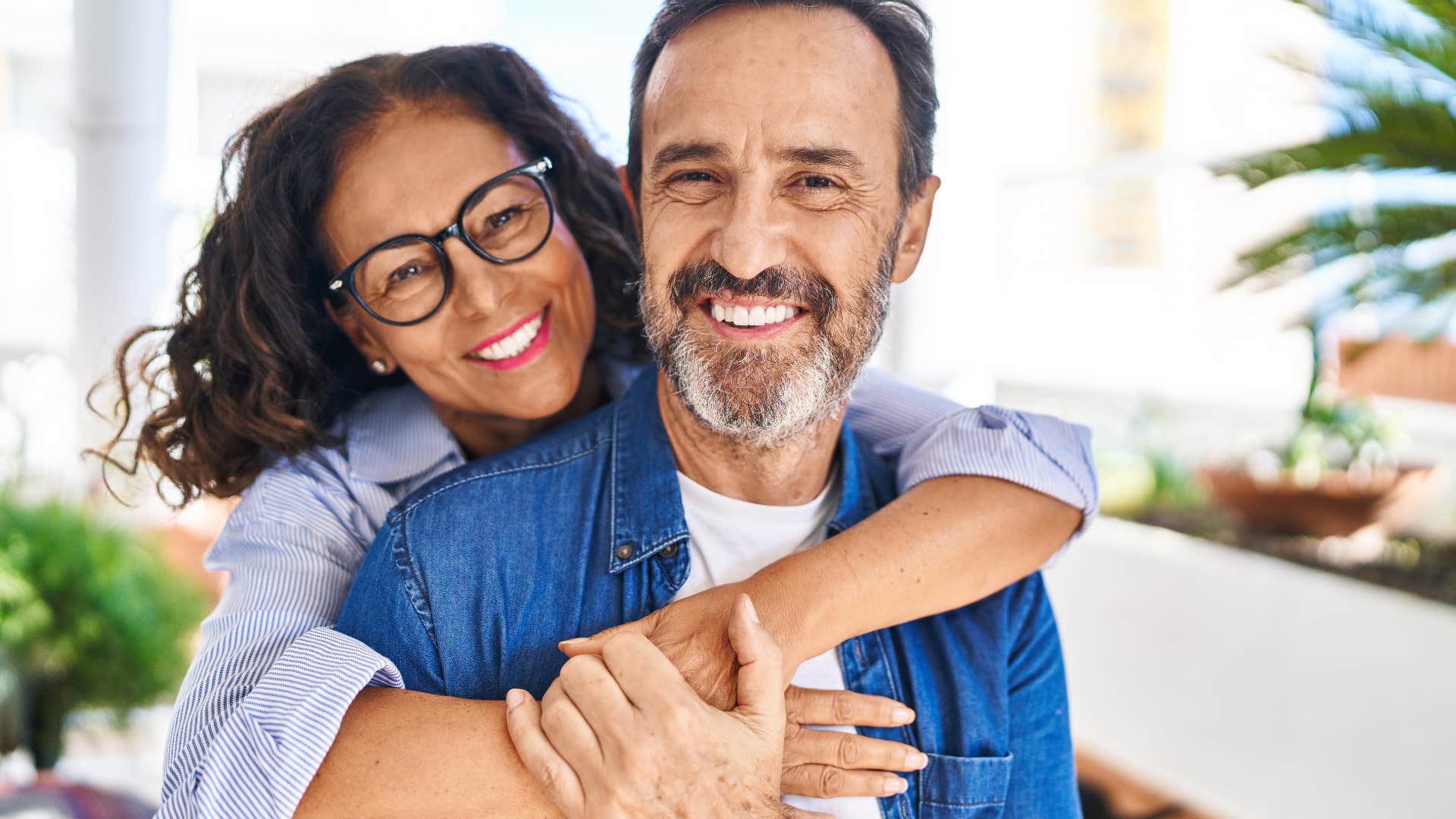 couple smiling together woman hugging man from behind