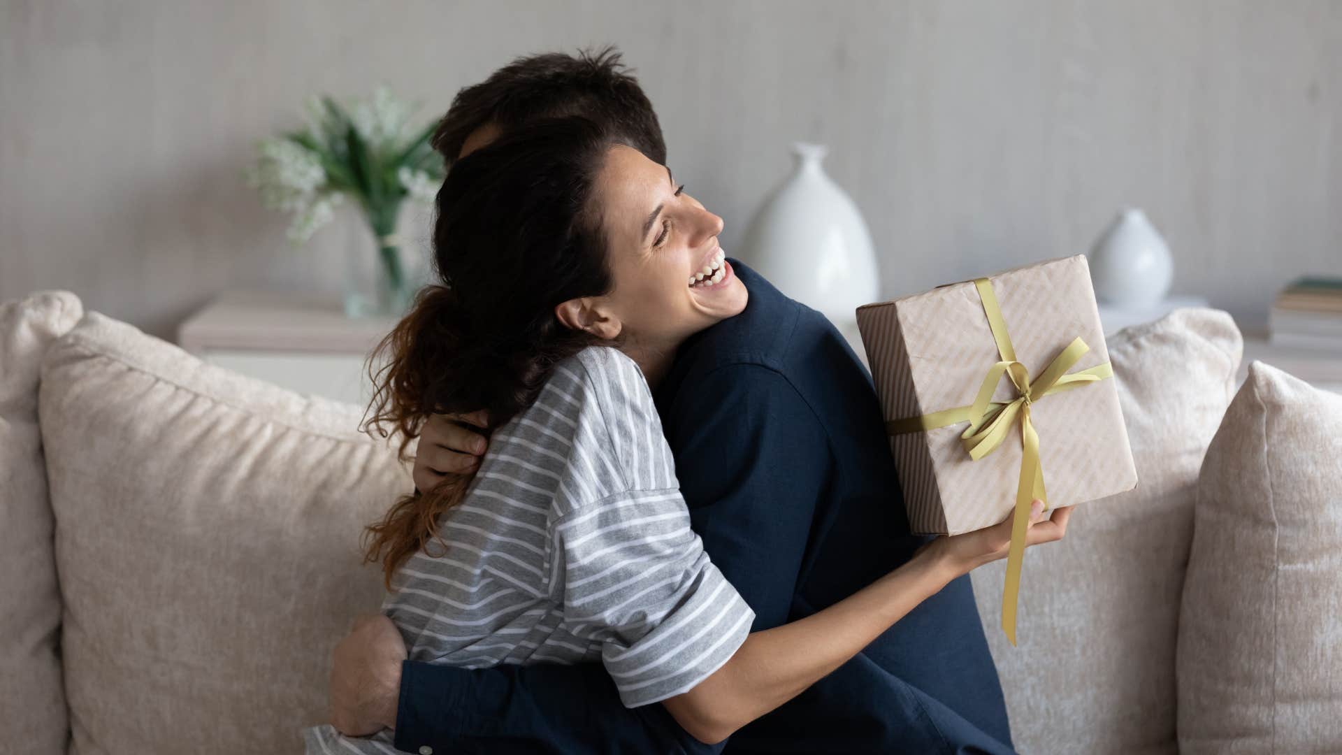generous man hugging woman after giving her a gift