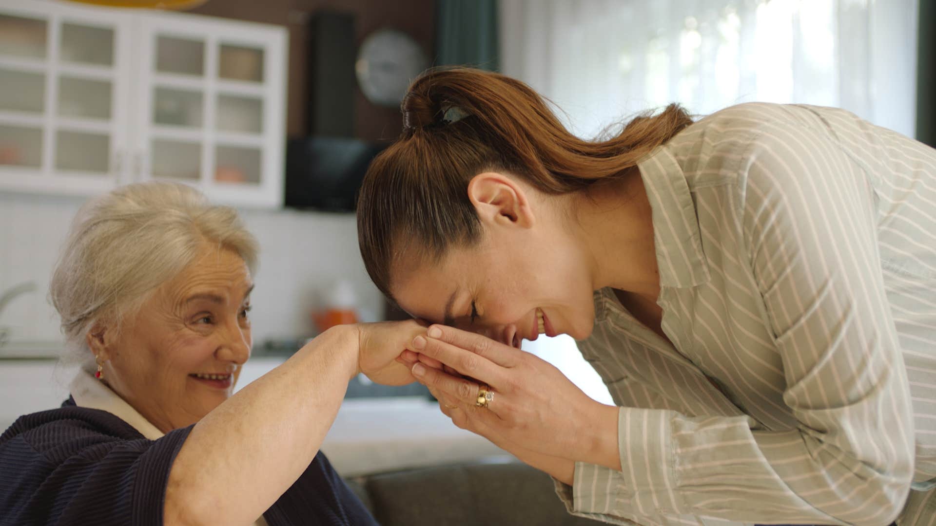 woman treating older family member with respect holding her hand
