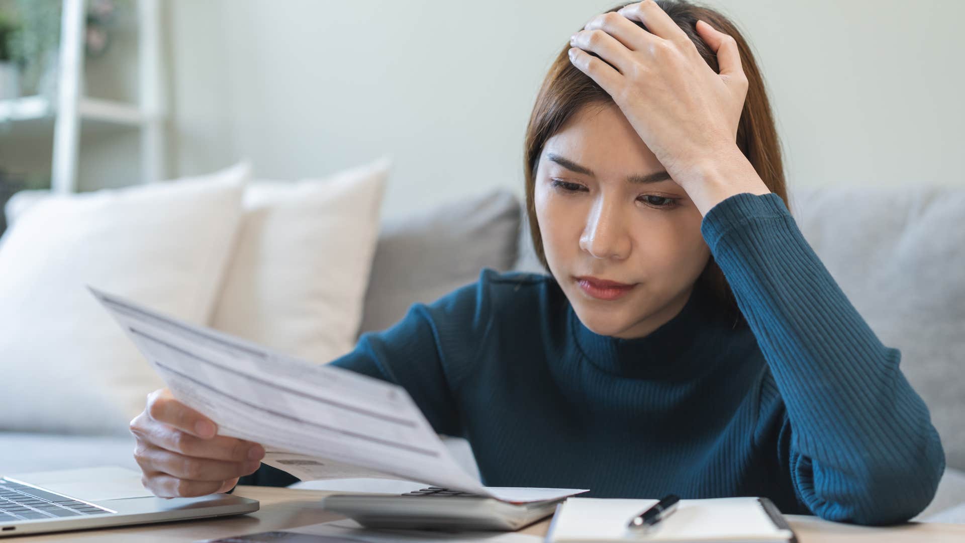 Woman who's less financially literate doing bills at home