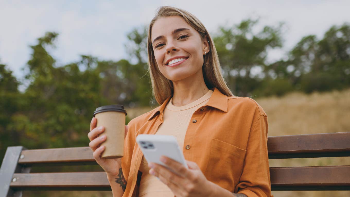 Reasons People Who Keep Their Phone On Silent 24/7 Usually Have smiling happy woman on her phone drinking coffee