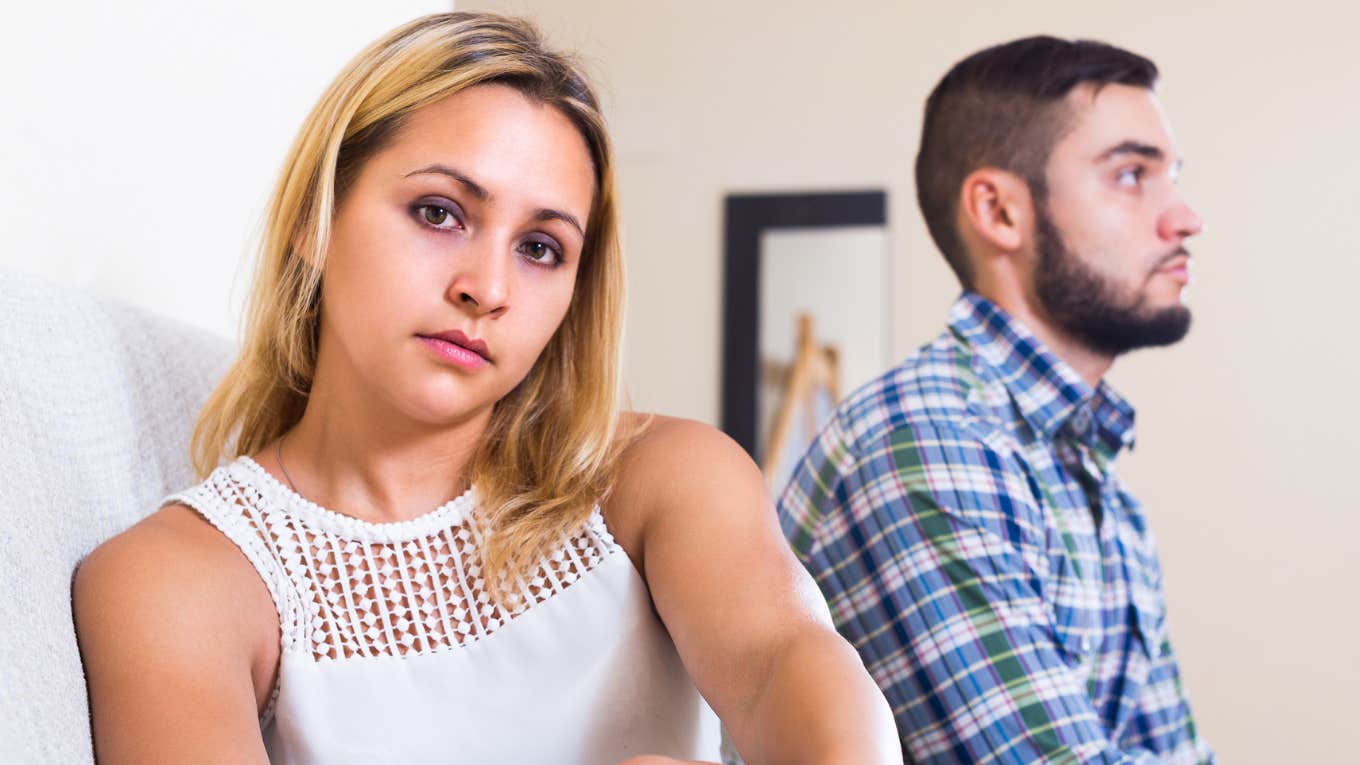 Red Flags People Ignore When They Marry Someone Who's Lazy woman looking annoyed sitting next to lazy husband