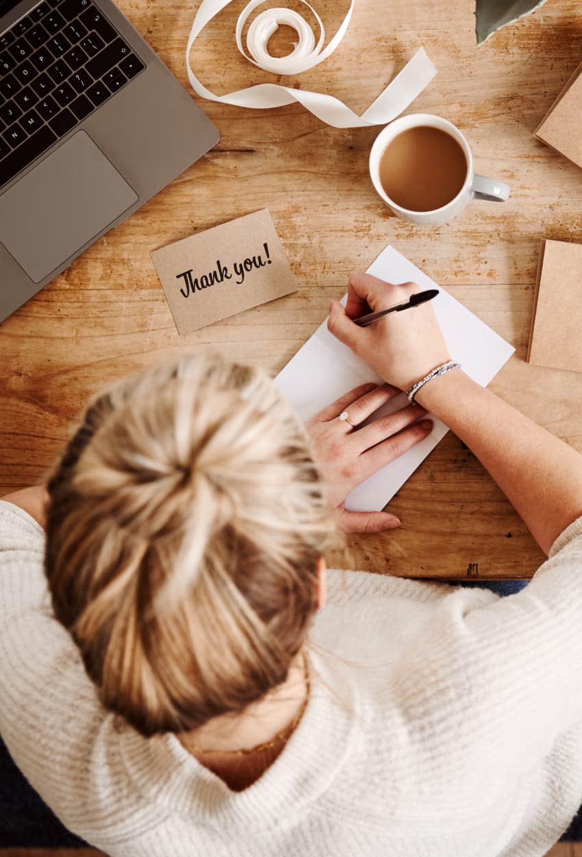 woman writing a thank-you note, an old-timey habit that is good for your mental health