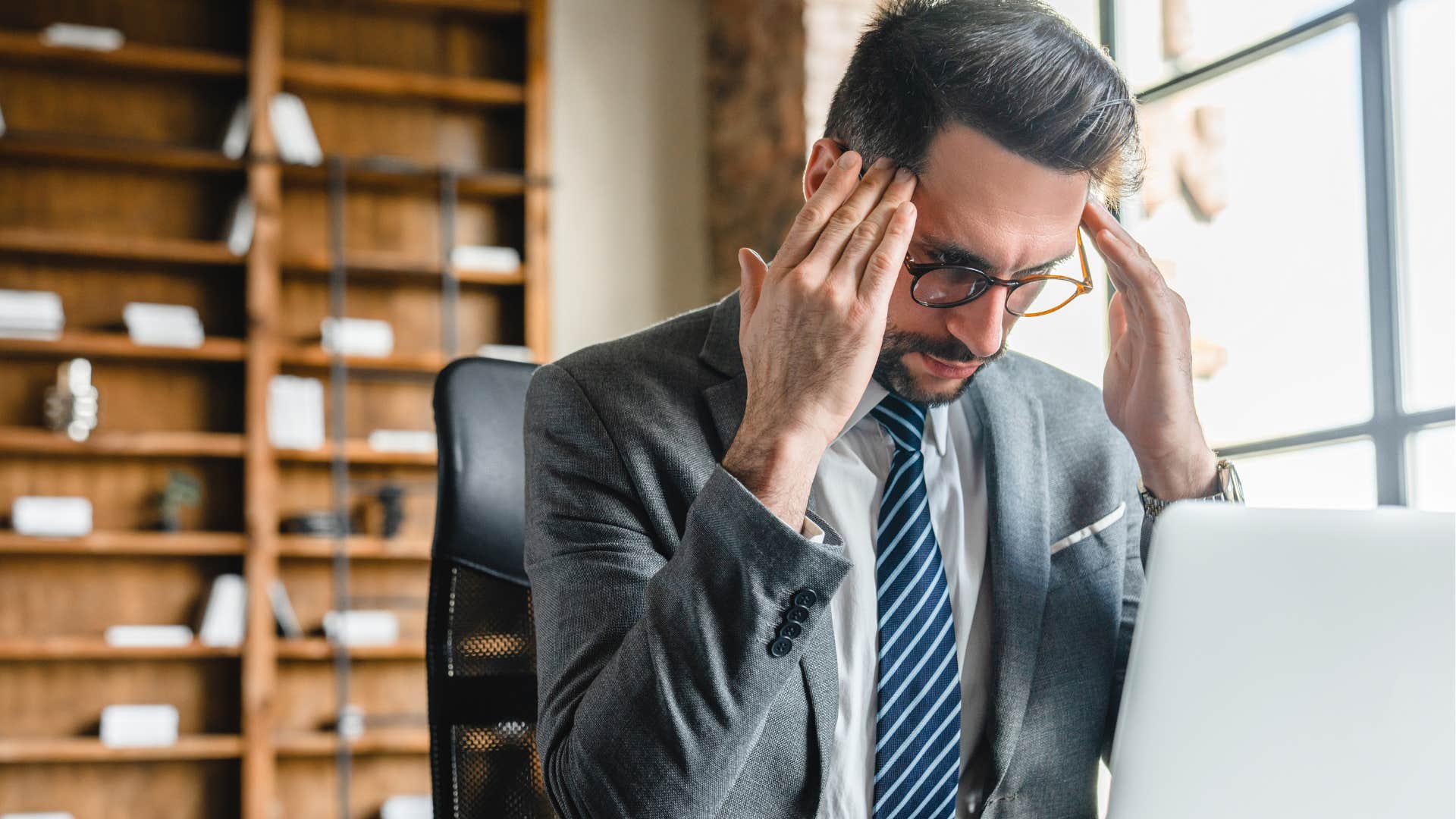 Frustrated man taking an AI interview at work.
