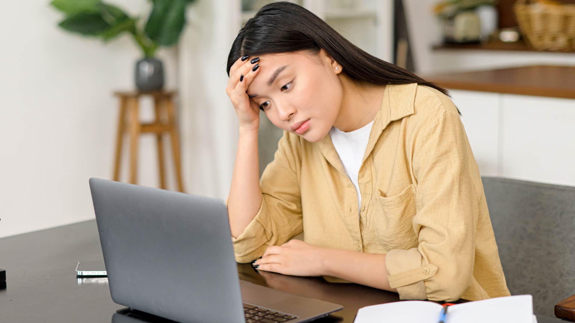 Woman whose resumes are being overlooked staring at her laptop.