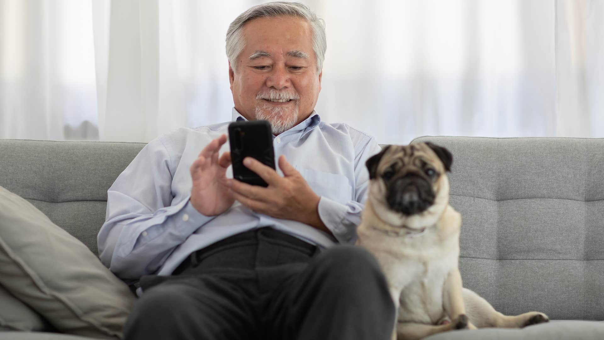 man on phone with dog next to him