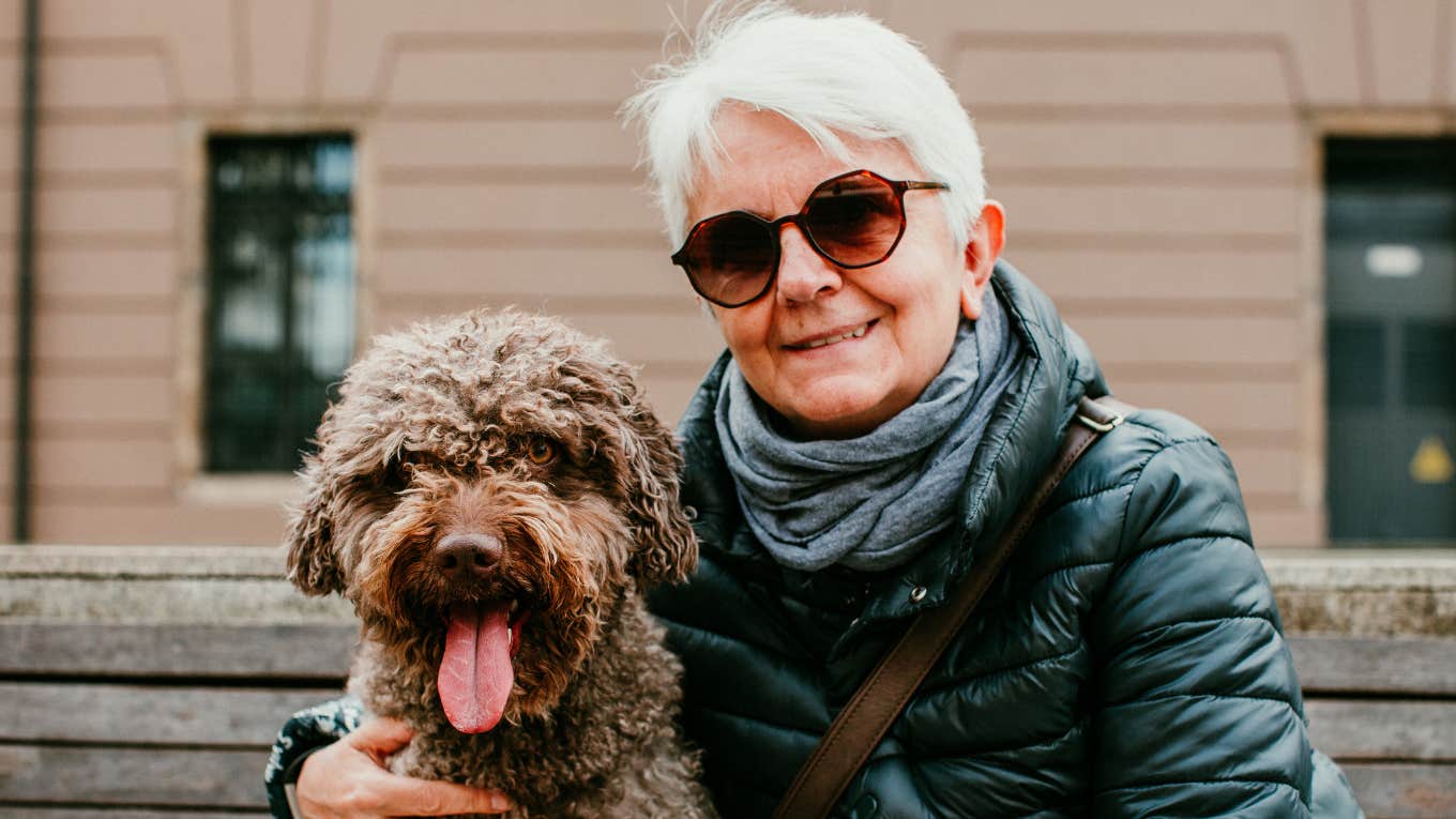 Signs A Boomer Grandparent Is More Attached To Their Dog Than Their Grandkids older boomer woman smiling next to her dog