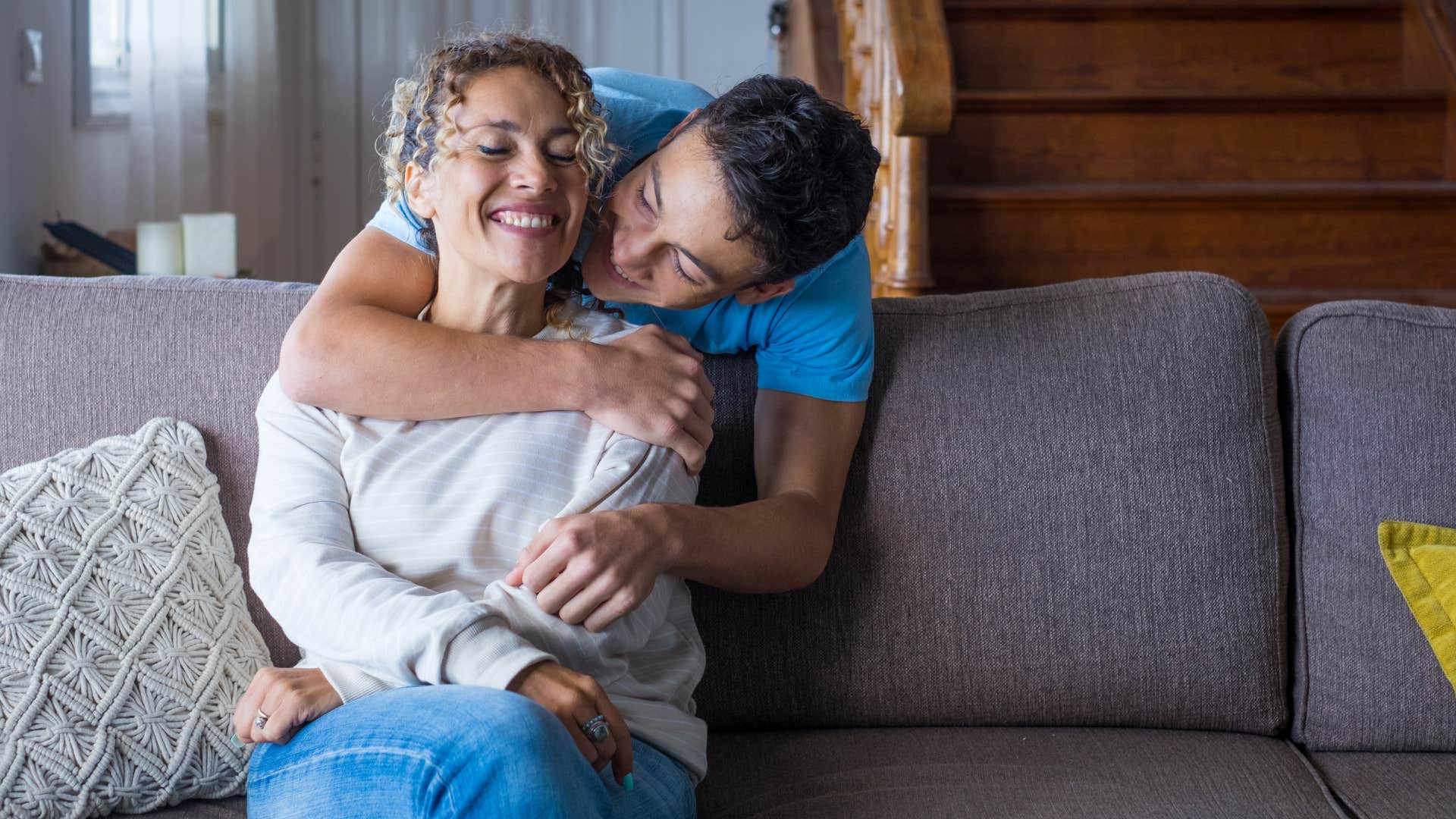 son hugging his mom from behind to keep the peace