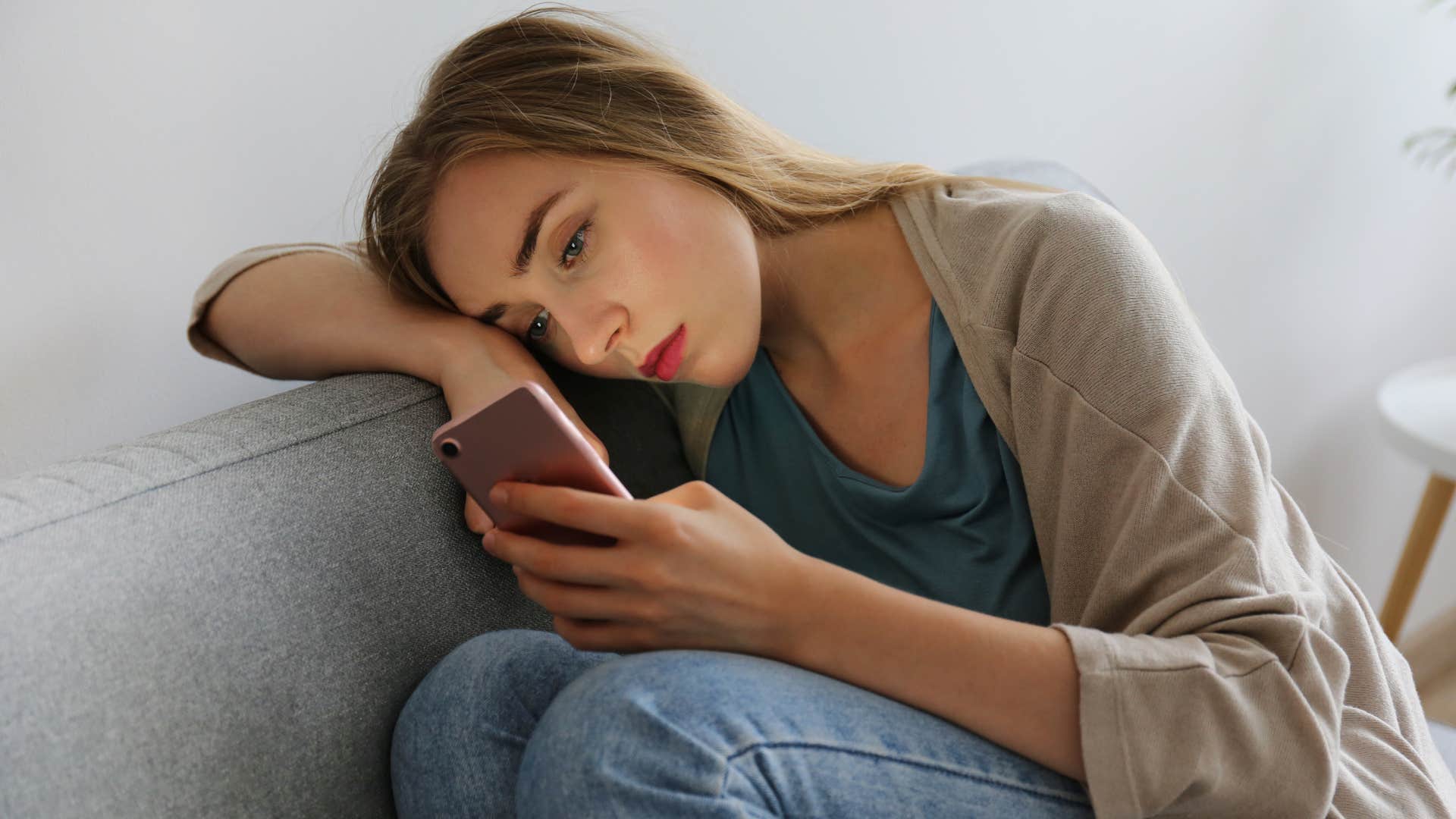 woman scrolling through phone comparing her relationship to others