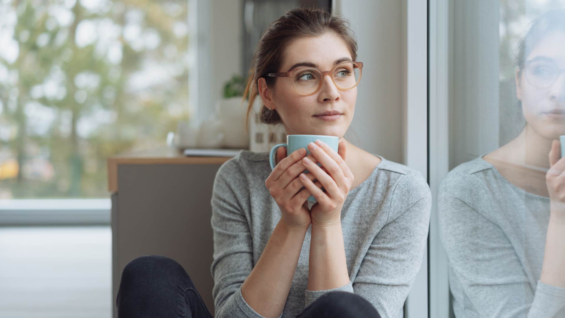 woman fantasizing about life without her partner as she drinks tea
