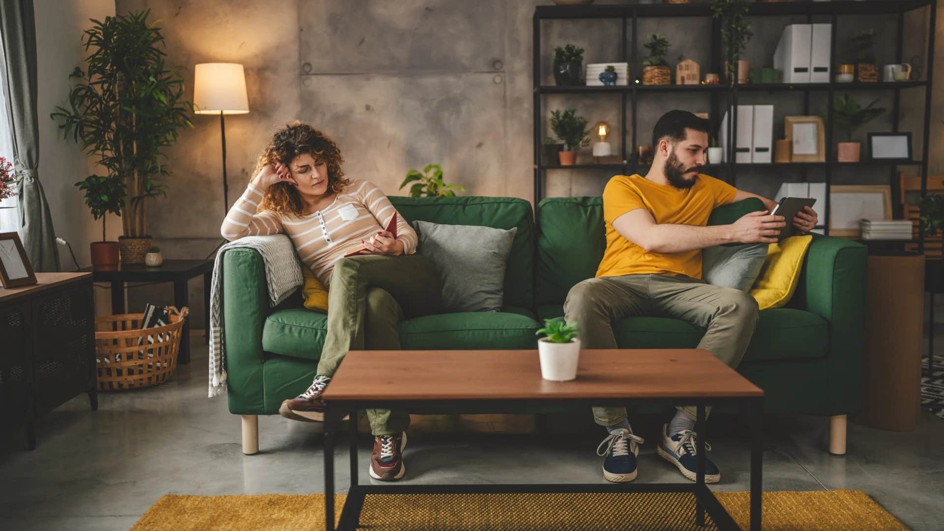 couple sitting on opposite ends of the couch in silence