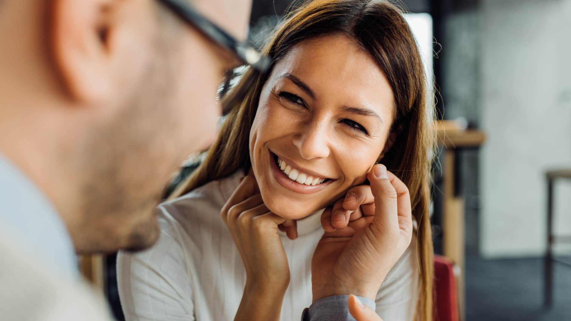 woman smiling as man touches her face