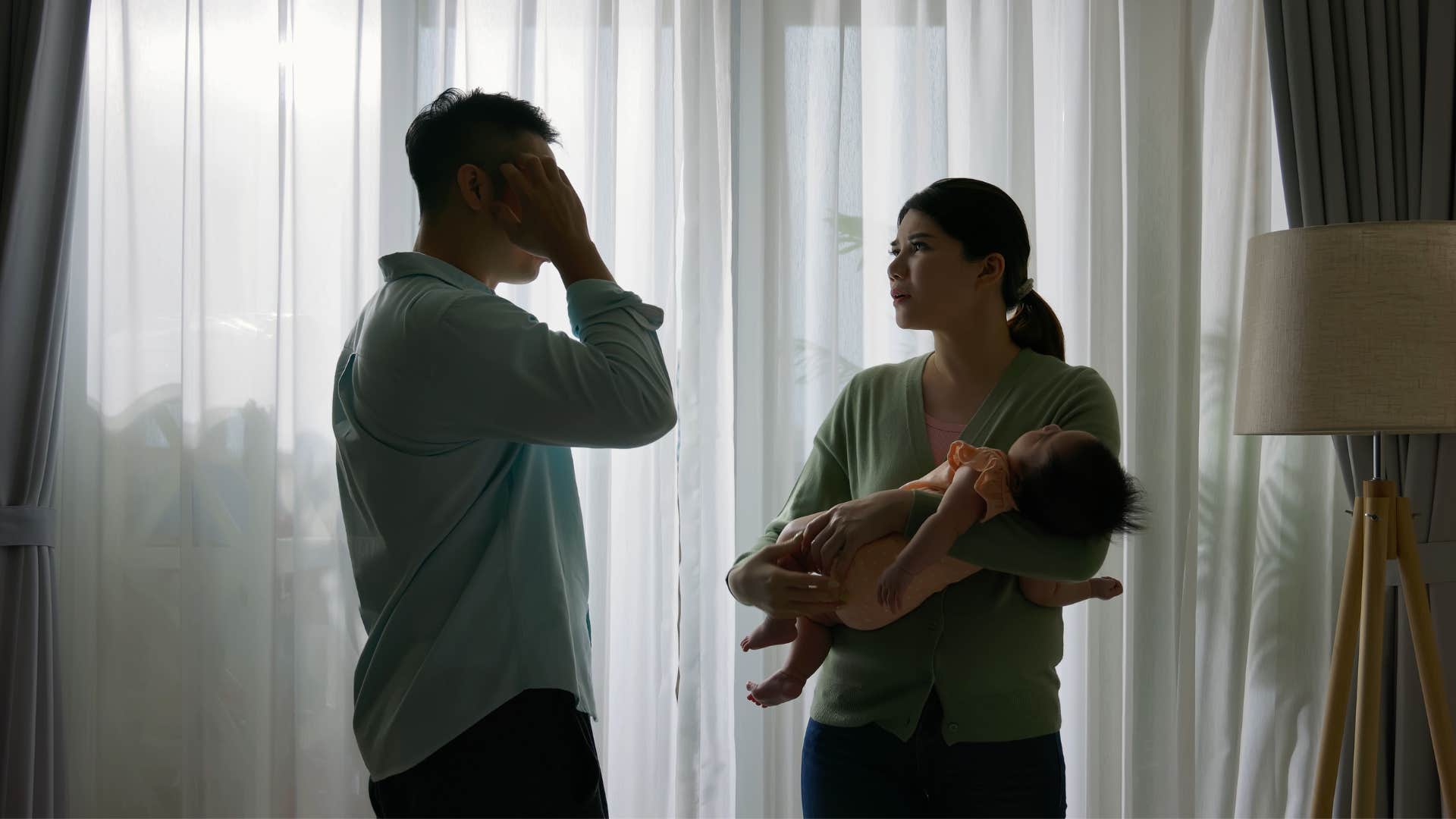 a man refuses to hold his child telling the mother that it is her job