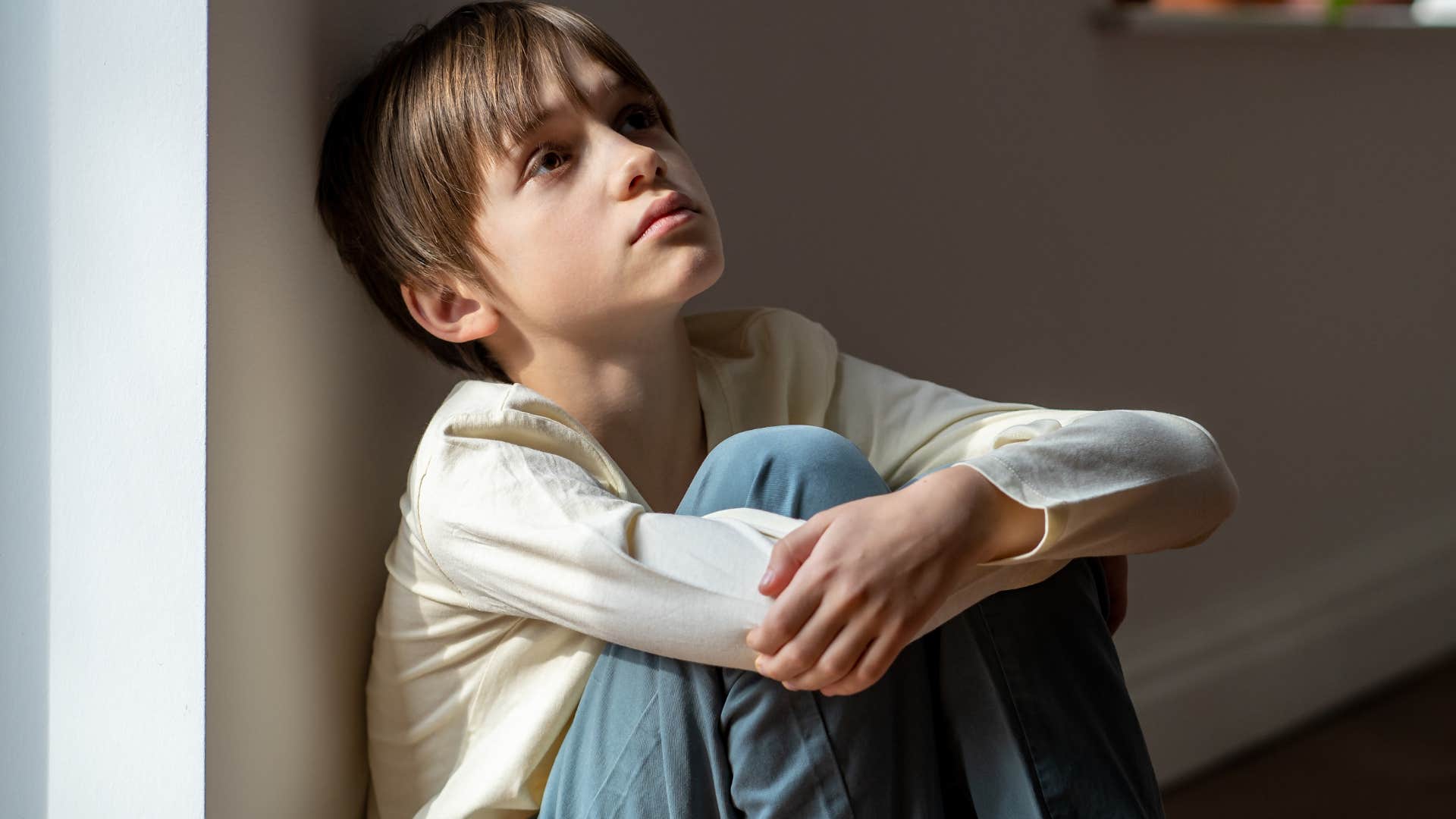 Little boy who never asked for help sitting alone on the floor.