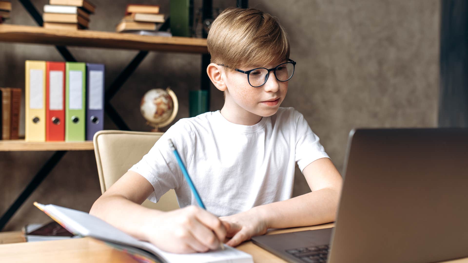 Little boy who craved solitude doing homework alone.