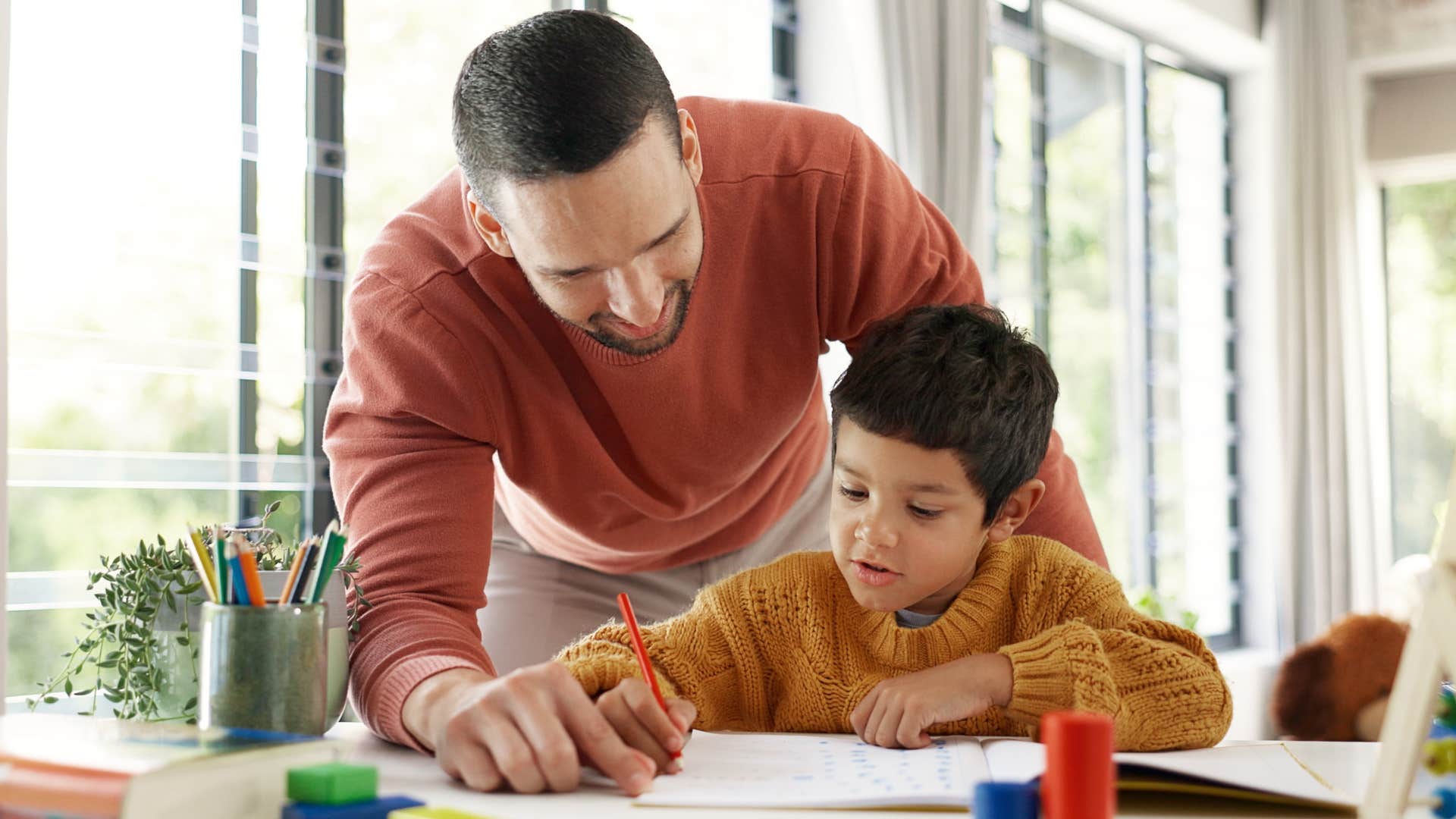 Dad smiling and helping his son with a low maintenance attitude.