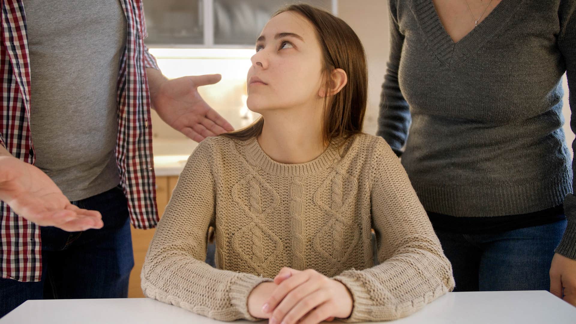 Young girl who never stood up for herself sitting in between her parents.