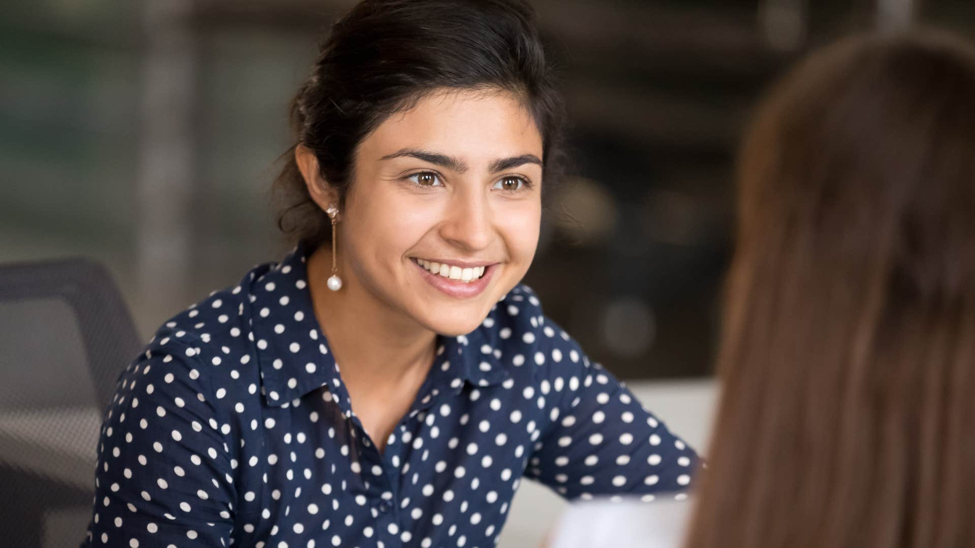 Woman who's not afraid of not knowing smiling at her peer.