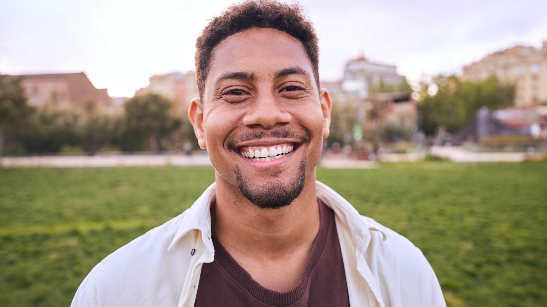 Man who doesn't subscribe to social norms smiling at the camera.