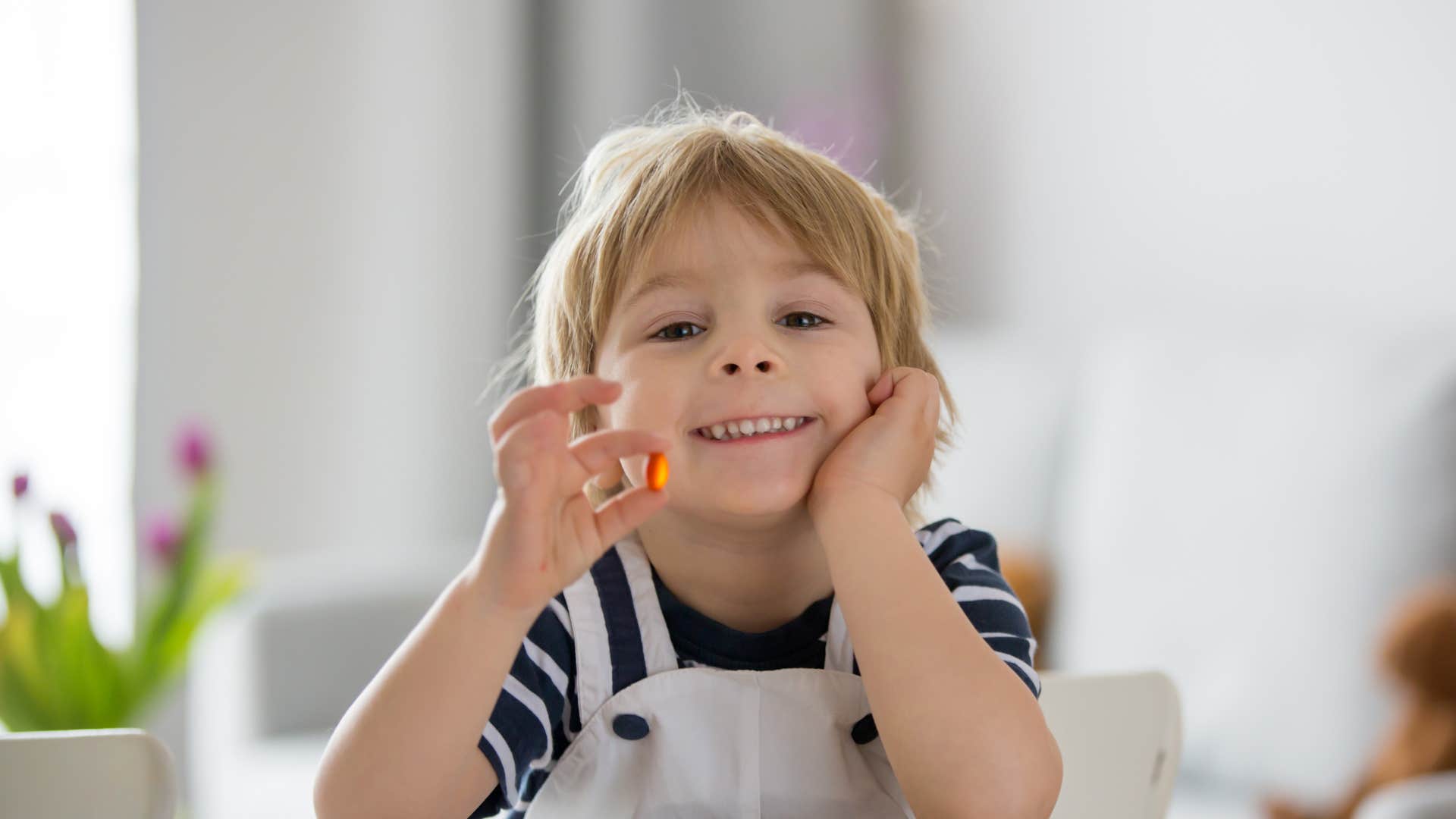 Kid enjoying the simple pleasure of a Flintstone vitamin